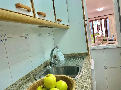 a kitchen sink with a bowl of apples in it at Los Balandros 117 by SunHousesCanarias in Maspalomas