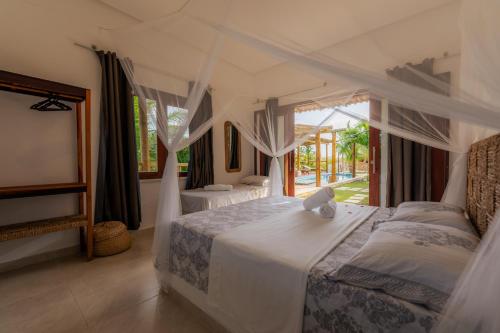 a bedroom with two beds and a large window at Villa Pousada 35knots Brasil in Ponta do Anel