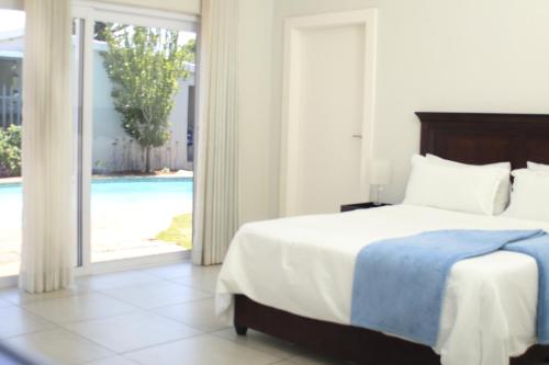 a bedroom with a bed and a sliding glass door at East Prestige lodge in Johannesburg