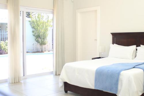 a bedroom with a bed and a large window at East Prestige lodge in Johannesburg