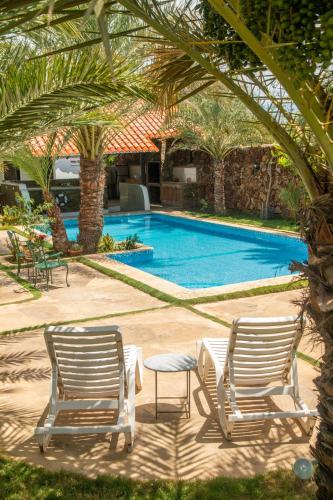 two chairs and a table next to a swimming pool at Playa El YAQUE Posada Yaque Sol, Isla de Margarita in El Yaque