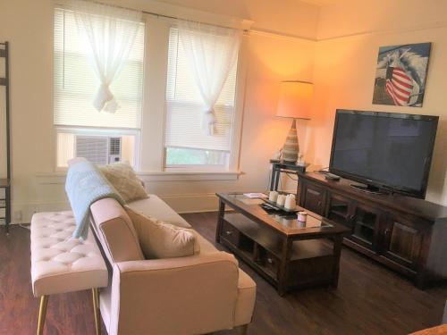 a living room with a couch and a flat screen tv at Entire cozy home in U-District in Seattle