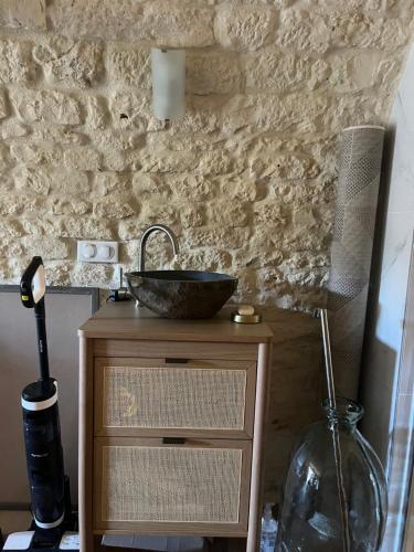 a bathroom with a sink on a wooden table at Voute des anges type loft sans cloison in Castelnau-Montratier