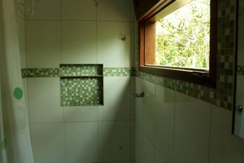 uma casa de banho com um chuveiro e uma janela em Casa Néctar em Lençóis