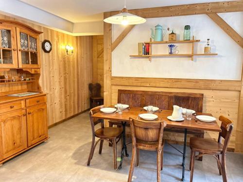 une salle à manger avec une table et des chaises en bois dans l'établissement Les Gets: Appartement central 2 ch, balcon, au pied des pistes - FR-1-623-132, aux Gets