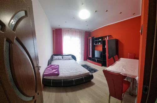 a small room with a bed and a table at Apartament Mia in Ocnele Mari