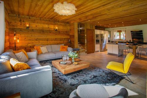 ein Wohnzimmer mit einem Sofa und einem Tisch in der Unterkunft Chalet Chamaline - OVO Network in Le Grand-Bornand