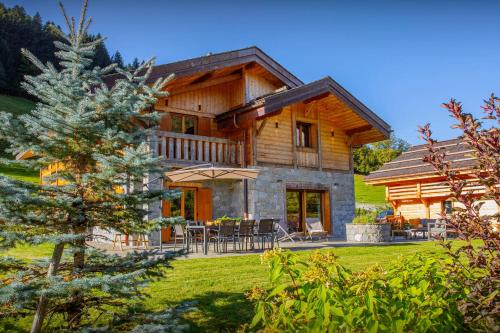 ein Blockhaus mit einer Veranda und einer Terrasse in der Unterkunft Chalet Chamaline - OVO Network in Le Grand-Bornand