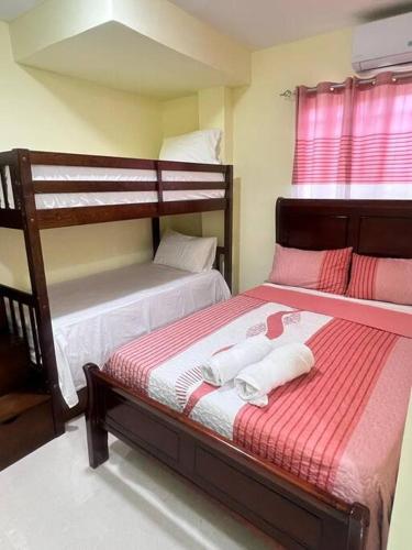 a bedroom with two bunk beds with red and white sheets at Hotel La Playa in Santa Cruz de Barahona