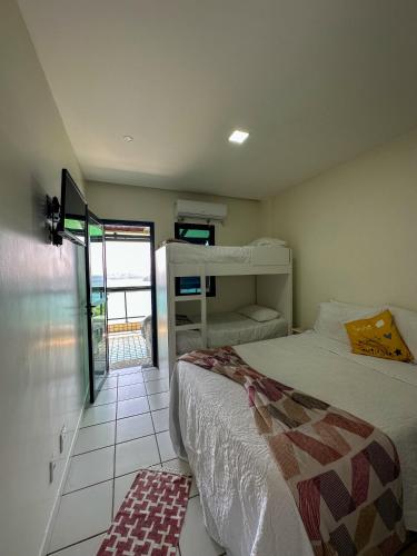 a bedroom with two bunk beds and a balcony at Apartamento no Porto Real Resort com vista espetacular p/ 6 adultos e 4 adolescentes in Mangaratiba