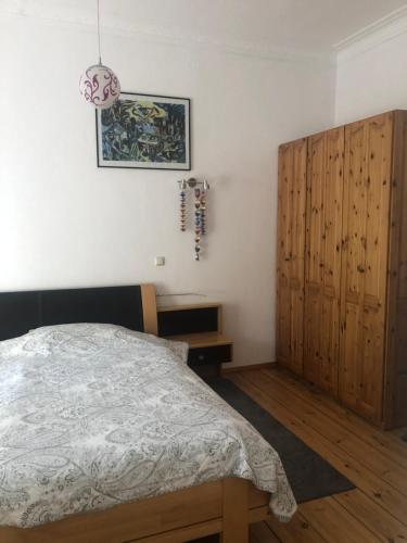 Schlafzimmer mit einem Bett und einem Holzschrank in der Unterkunft Lioba Drescher Hendel in Berlin
