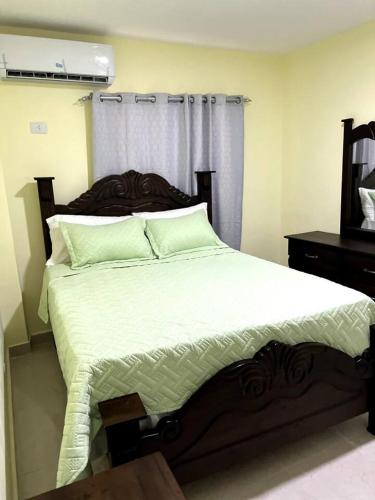 1 dormitorio con 1 cama grande y cabecero de madera en Hotel La Playa en Santa Cruz de Barahona
