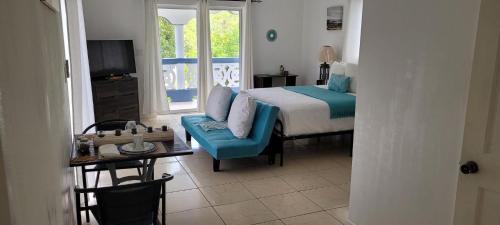 a bedroom with a bed and a table and a television at Villa Serenity by the Water in Providenciales