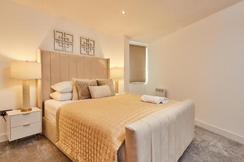 a bedroom with a large bed and a lamp at Modern Leeds Dock Apt &Free Secure Parking! in Leeds