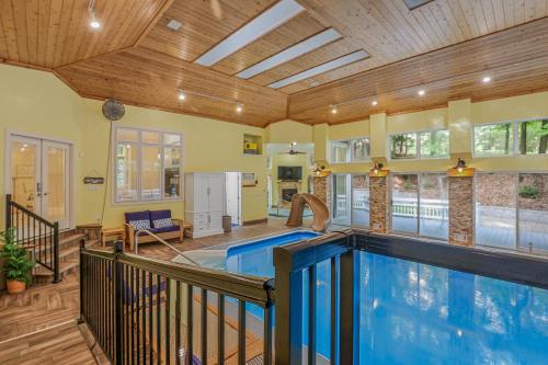 a swimming pool in a house with a ceiling at Indoor Pool near Grand Haven with Lake Michigan Beach! in Norton Shores