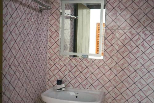 y baño con lavabo y espejo. en Satvik Stays en Puri