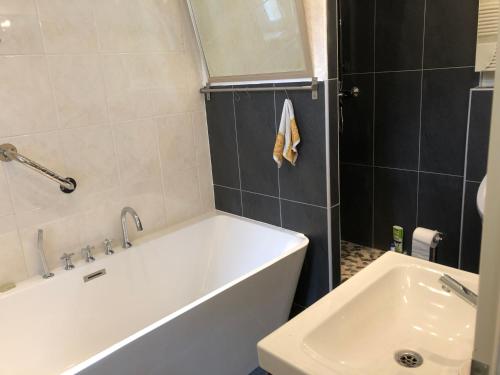 a bathroom with a white tub and a sink at Lioba Drescher Hendel in Berlin