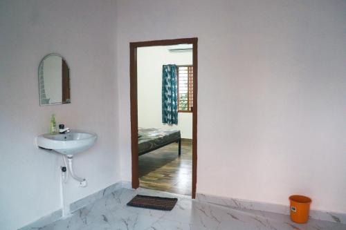bagno con lavandino e specchio di Satvik Stays a Puri