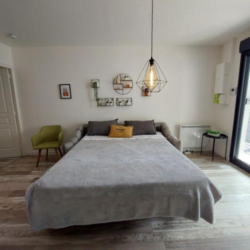 une chambre avec un grand lit et une chaise verte dans l'établissement F2 Hypercentre Terrasse Talleyrand, à Reims