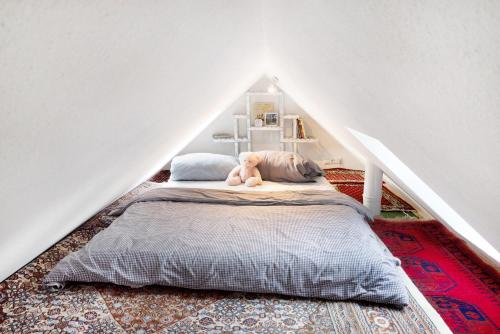 Un dormitorio con una cama con un osito de peluche. en tinyhouse-gem-kleinodye, 