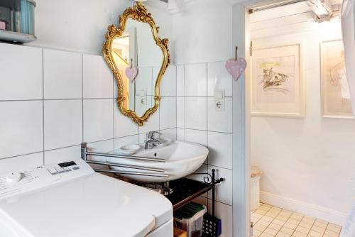 Baño blanco con lavabo y espejo en tinyhouse-gem-kleinodye, 