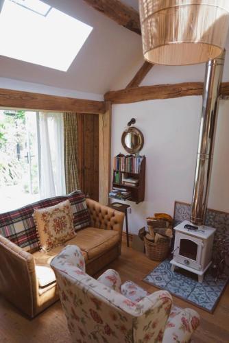 a living room with a couch and a stove at Nest Holiday Hideaway Dove Cottage-Beautiful Location in the Long Mynd Area of Outstanding Natural Beauty-WHIRLPOOL JACUZZI BATHS!! in Picklescott