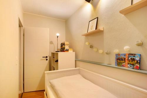 Una pequeña habitación con una cama y un estante. en Ferienwohnung Bergwiese, en Schmallenberg
