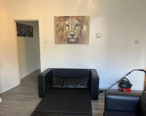 a living room with a couch and a painting of a lion at Cosy central apartment near Stokes Croft in Bristol