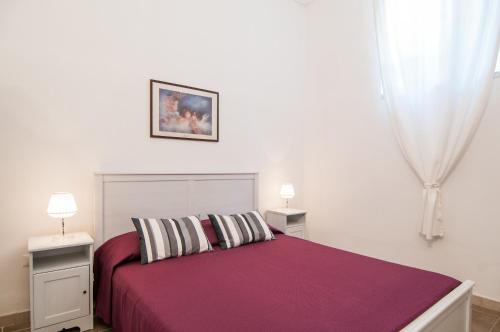 een slaapkamer met een paars bed met 2 tafels en 2 lampen bij Casa vacanze Cristina in Noto