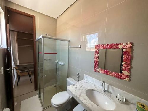 a bathroom with a toilet and a sink and a mirror at Villa Simone in Natal