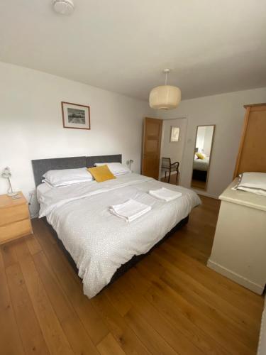 a bedroom with a large bed with white sheets at The Old Post Office,Hassocks in Ditchling