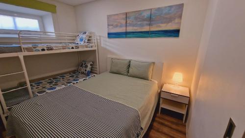 a small room with a bed and a bunk bed at Casa Vila Praia in Sesimbra