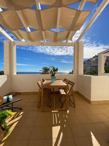 eine Terrasse mit einem Tisch und Stühlen auf dem Balkon in der Unterkunft SOFIA PLAYA LAS VENTANICAS in Mojácar