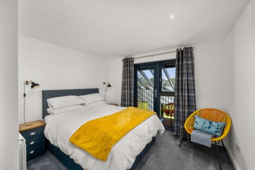 a bedroom with a bed and a window and a chair at Wester Den in Arbroath