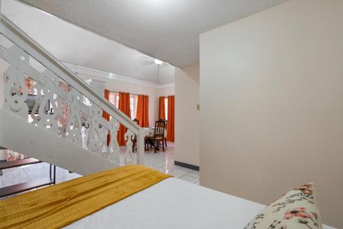 a bedroom with a bed and a staircase at Shaw Park Gem Apt 12D in Ocho Rios