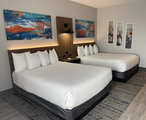 um quarto de hotel com duas camas e pinturas na parede em La Quinta by Wyndham Stephenville em Stephenville