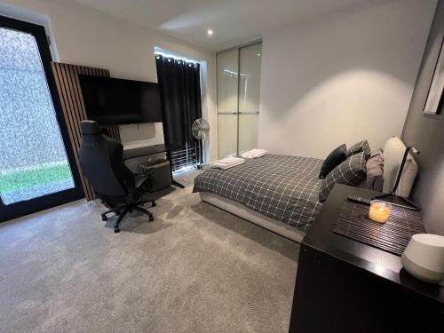 - une chambre avec un lit, un bureau et un ordinateur dans l'établissement Staines Home Stay, à Staines upon Thames