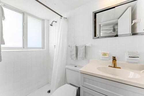 La salle de bains blanche est pourvue d'un lavabo et d'un miroir. dans l'établissement Wonderful 3br Steps To The Beach Wheated Pool, à Fort Lauderdale