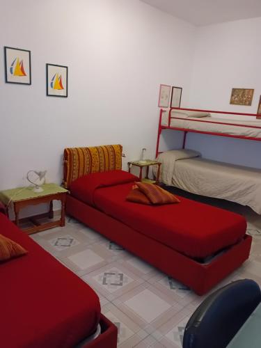 sala de estar con 2 camas y sofá rojo en Palazzo Scavone, en Palermo