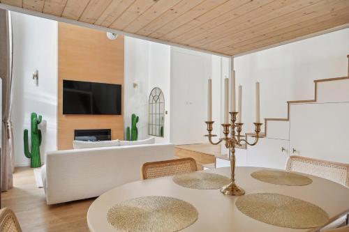 a dining room with a table and chairs and a couch at Suite luxueuse avec jardin privé Sauna et Jacuzzi in Paris