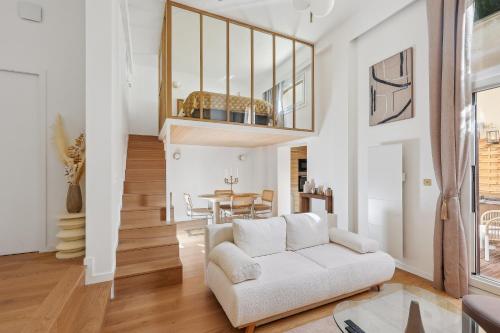 a living room with a white couch and a table at Suite luxueuse avec jardin privé Sauna et Jacuzzi in Paris