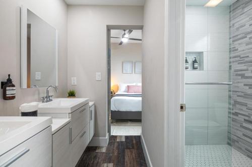 a bathroom with two sinks and a shower with a bed at Oasis Jumbo - Complex for Big Groups in Fort Lauderdale