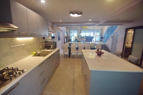 a kitchen with white cabinets and a counter top at Neverland Hua Hin - Beach Retreat Home in Hua Hin