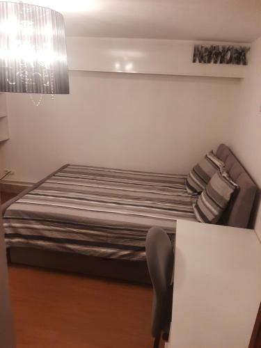 une chambre avec un lit et une table avec une chaise dans l'établissement Maison d'ozoir, à Ozoir-la-Ferrière