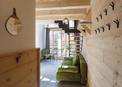 un soggiorno con divano verde e parete in legno di Chalet Bio Corti Spa 4 personnes a Champagny-en-Vanoise