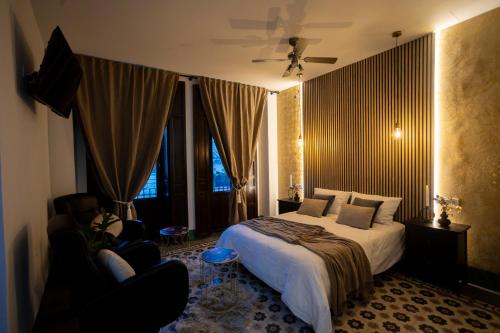 um quarto com uma cama, uma cadeira e uma janela em Luxury Macabeo 25 em Novelda