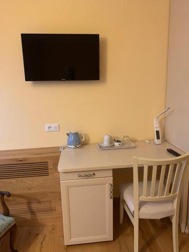 a desk with a chair and a television on a wall at Agriturismo coda di gatto in Eraclea