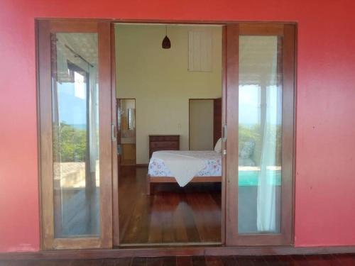una camera con porte scorrevoli in vetro che conducono a una camera da letto di A janela do amanhecer a Maxaranguape