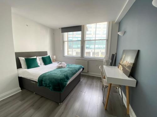 a bedroom with a bed and a desk and a window at Stylish Central Escape in London