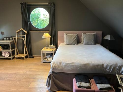 a bedroom with a large bed with a window at B&B Des Heures Claires in Lasne